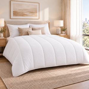 Couette 4 Saisons Sensifibre blanche sur un lit, matelassage vertical