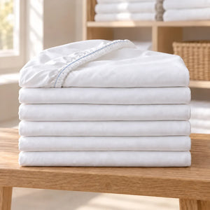 Lot de 6 draps-housses hôtel blancs avec surpiqûre bleue intérieure sur l’élastique
